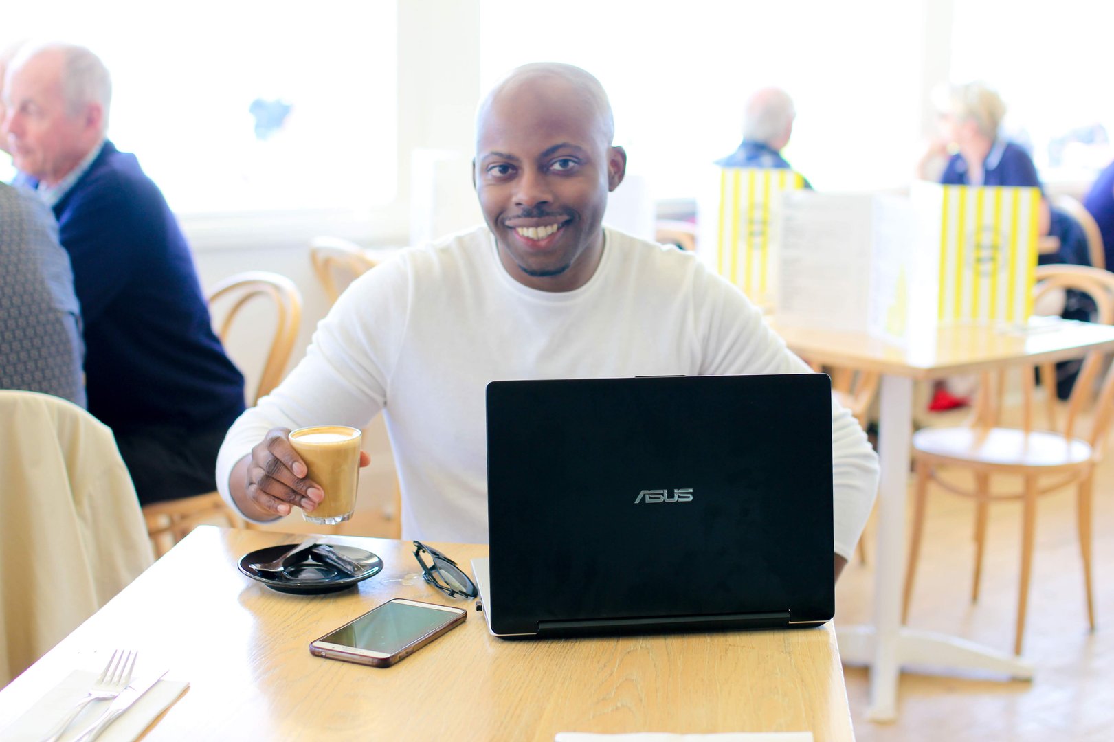 Desk with a laptop, phone and coffee, planning an AI SEO strategy